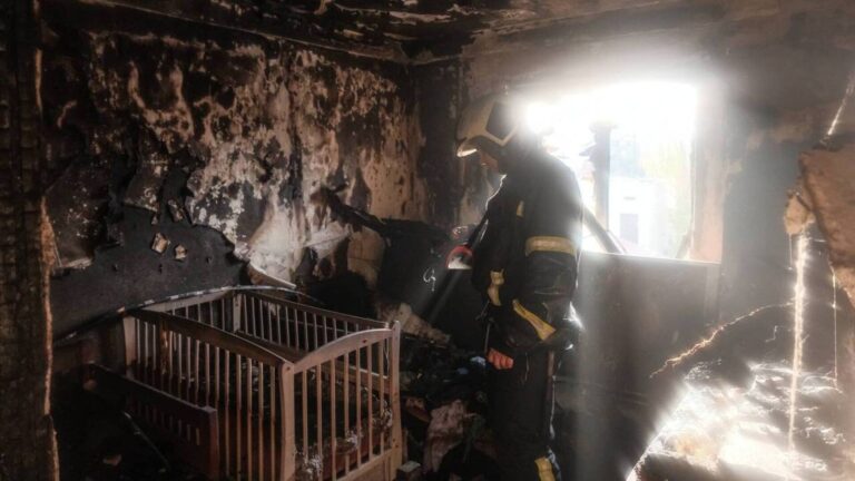 Київський рятувальник бореться з вогнем у своїй квартирі після атаки артилерії